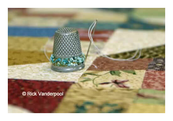 Pretty thimble with threaded needle