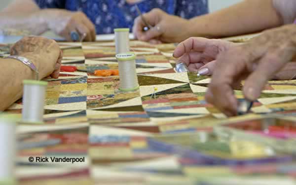 Hands sewing a quilt